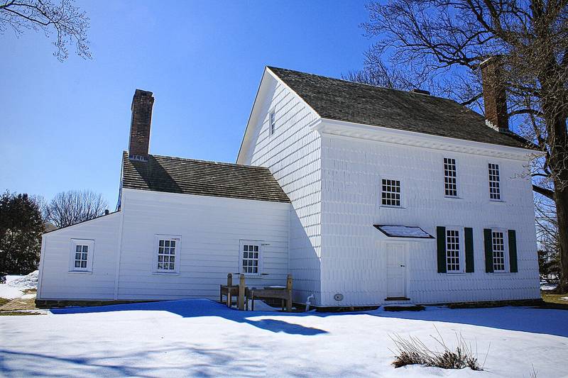 The white shingled Covenhoven House in winter snow